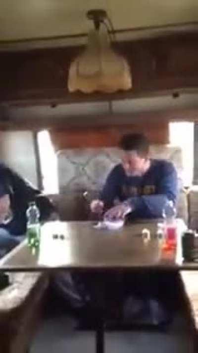 Two people trying to eat Surströmming (fermented fish!), A typical swedish dish. It is said that the smell is so strong that the recommendation is to open the can outside the house, inside a bucket full of water.