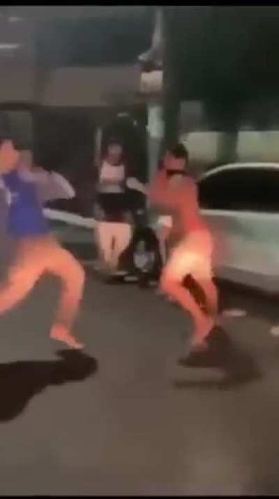 Guy in the blue shirt has some training. He stuns shirtless guy's leg with a few kicks to the knee.