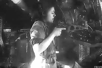 (April 1945) A WAAAF (Women's Australian Auxiliary Air Force) member test firing a .50-inch Browning machine gun from the Liberator aircraft's waist gun position.
