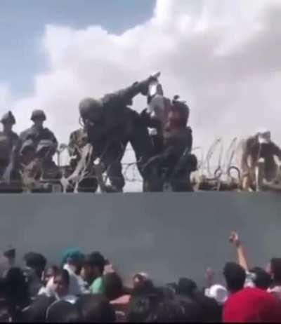 Asshole soldiers giving a baby to afghan refugees