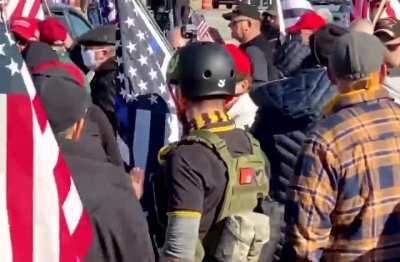 Aggressive, anti-Trump protestor enters pro-Trump crowd to instigate. As he is being nonviolently told to leave the crowd, he suddenly shoves an old lady to the ground who is wearing a MAGA hat.