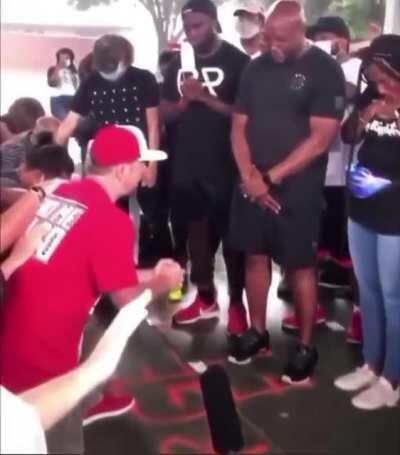 White peoples kneeling down, asking for forgiveness from Black community.