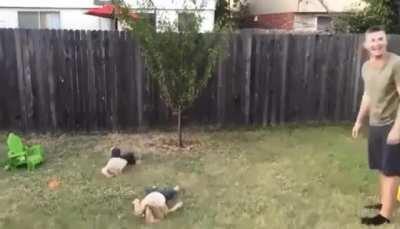 Man Teaching his daughters how to do cartwheel.