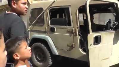 Heavily armed Israeli soldiers arrest a Palestinian child