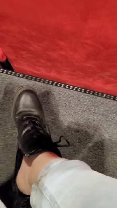 Barefoot in leather boots, taking them off at the cinema