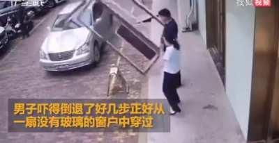 Window falls and bounces off car, narrowly avoids two people next to it