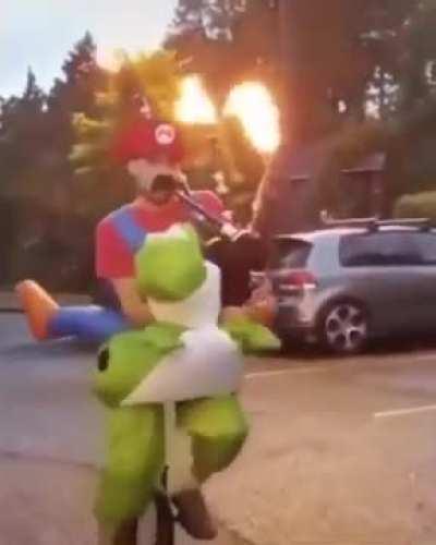 Guy in a Mario costume plays a bagpipe flamethrower while on a unicycle