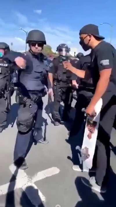 Riot cop grabs and throws a protestor's phone. Protestor bitch slaps him into next Tuesday and legs it.