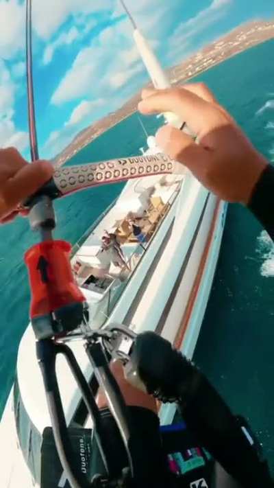 Kite boarding over a yacht