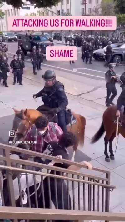 ICE agent on horse beats a protester with a stick during a demonstration in Los Angeles