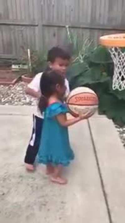 Big brother helps little sister make the shot