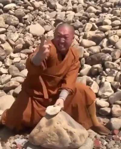 Monk brakes stones with his hands/fingers