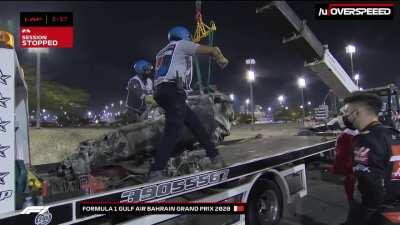The survival cell of Grosjean's car being lifted onto a tow truck