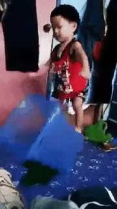 Kid tries to pin the hamper