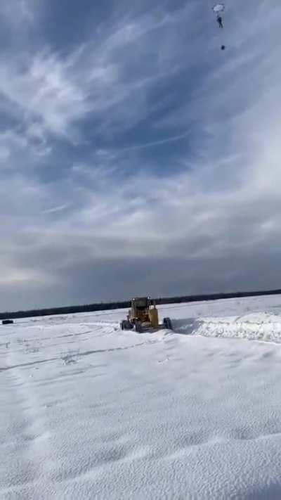A paratrooper hits a tractor, the only thing in a wide open field
