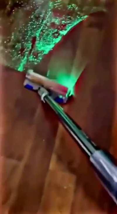 Vacuum cleaner with a laser