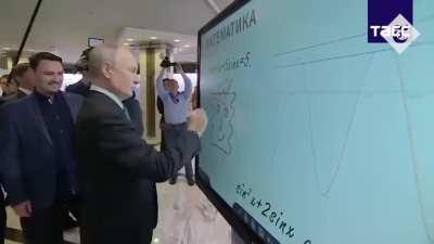 Putin drawing a weird face on a whiteboard