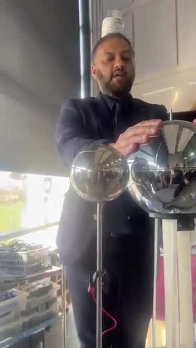 Teacher demonstrates static electricity in a different way using cups flying off his head