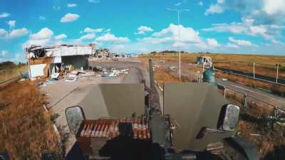 Ukrainian soldiers are crossing the border in their Hummer. The buildings the vehicle is passing by are the ruined enemy checkpoint, where they once managed to capture a significant number of prisoners. Checkpoint Sudzha, Kursk region.