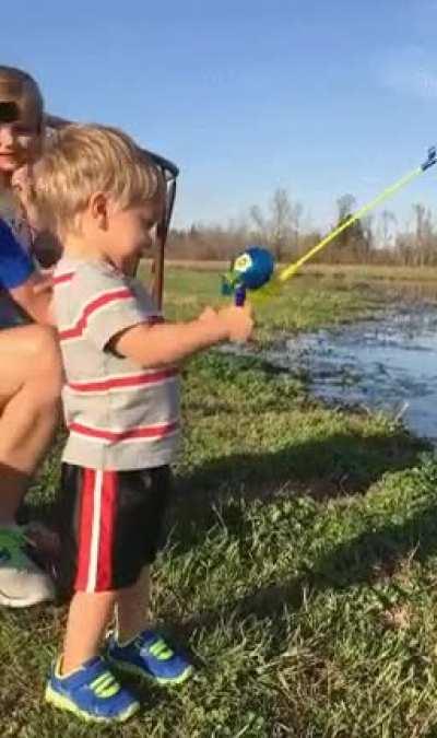Kid catches fish with toy fishing rod