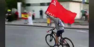 Counter protestor at a nationalist rally at Spain shows up the red flag