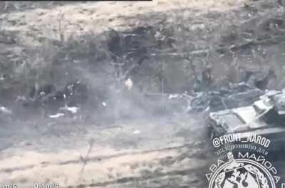 RU pov: UA soldier in a trench fires a RPG at a RU tank from close range, but it fails to penetrate and ricochets off of the tank.
