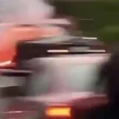 LA rioter lights firework on the street. Gets it thrown back into his car.