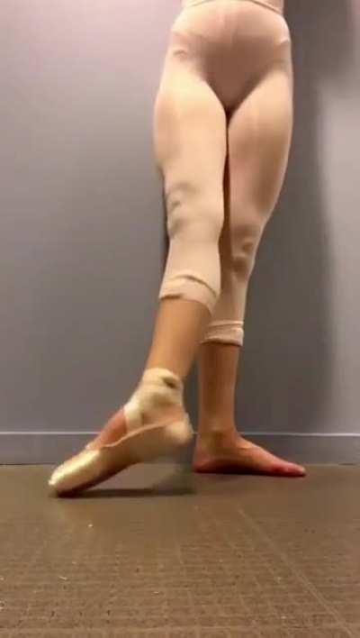 Contrast between the ballerina's bare feet and her pointy shoes.