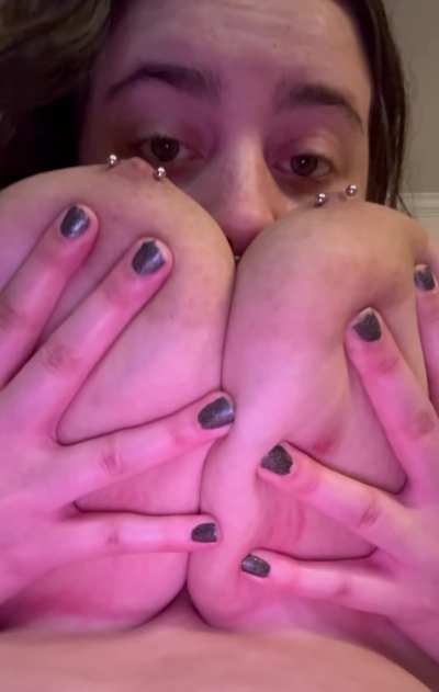 Smothering her pierced tits on her face