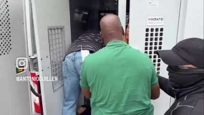 A young boy tries to console his mother as ICE loads them into the back of a van