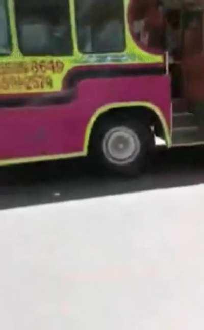 WCGW waving while standing on the side of a moving bus in a Spider-Man suit