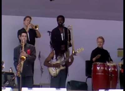 Sade removes jacket to reveal turtleneck, crowd loses it.