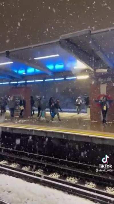 People having fun with a playful snowball fight on the tube platform. Love this!