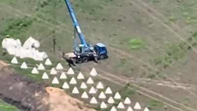 A Ukrainian Kamikaze Drone flies into a Truck with a Crane whilst it places Dragons Teeth fortifications in Belgorod Oblast. Failing to Detonate upon impact. (Published 18/06/2023)