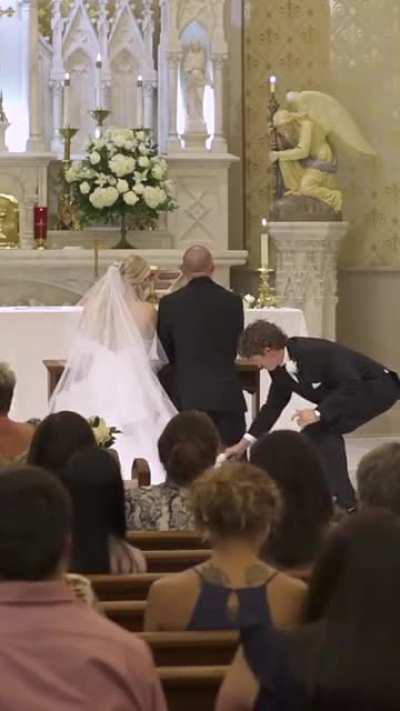 Best man fixes groom suit during wedding