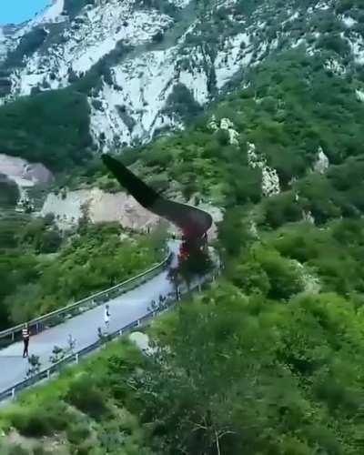 Transporting a massive wind turbine blade up a winding mountain pass.