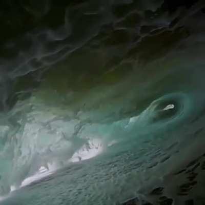 Wave crashing over a photographer