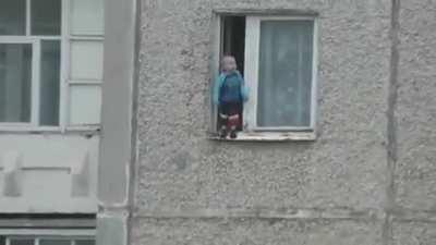 Russian Kid Checks Out The View From His Window.
