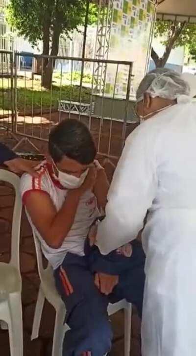 Brazillian first responder with fear of needles passes out while taking Covid vacine.