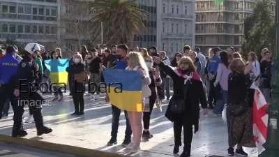 A Georgian woman hits a Russia supporter with a Ukrainian flag in Athens