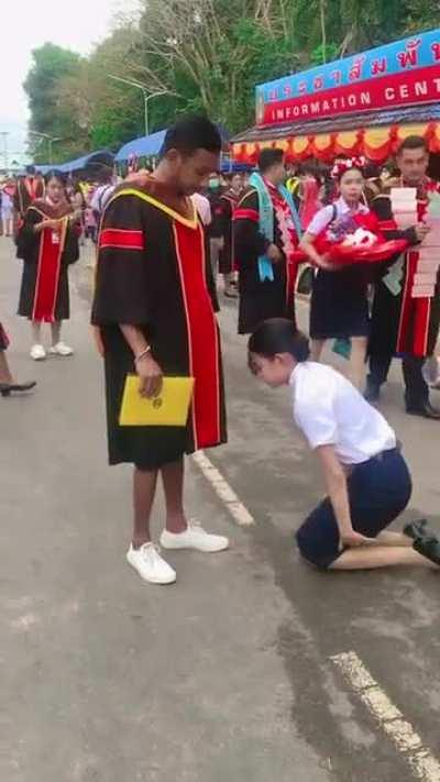 Thai woman kneels & bows down to brother who gave up his education so she can graduate