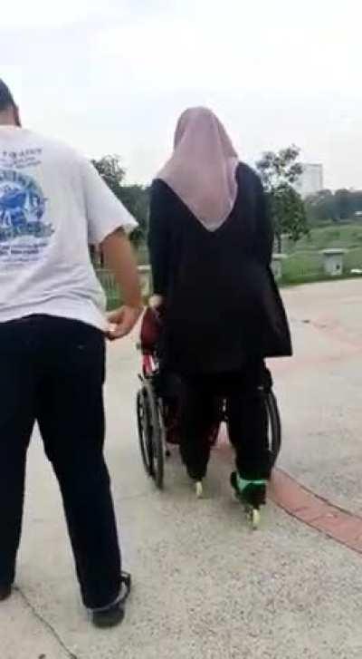 Wearing rollerblade while pushing elderly on wheelchair 