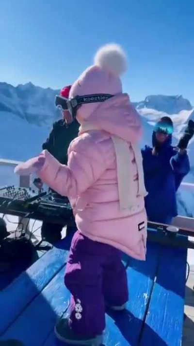 Baby dancing to house music at a ski resort