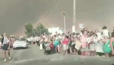 Hundreds of tourists and locals evacuate via roads to get away from wildfires