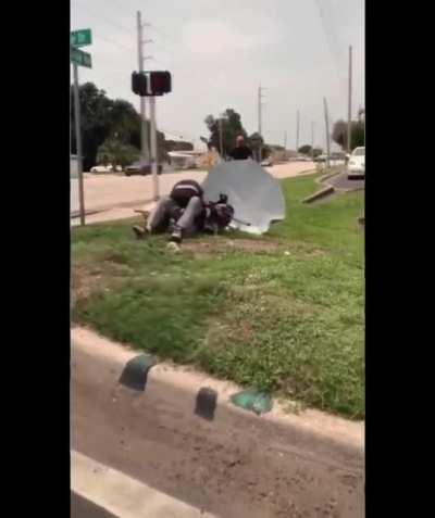 Homeless man fighting motercyclist get in dogpile.