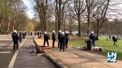 Riot police evacuates a crowded park in Brussels with mace, horses and watercannons. People reply by massively pelting police with stones and bottles.