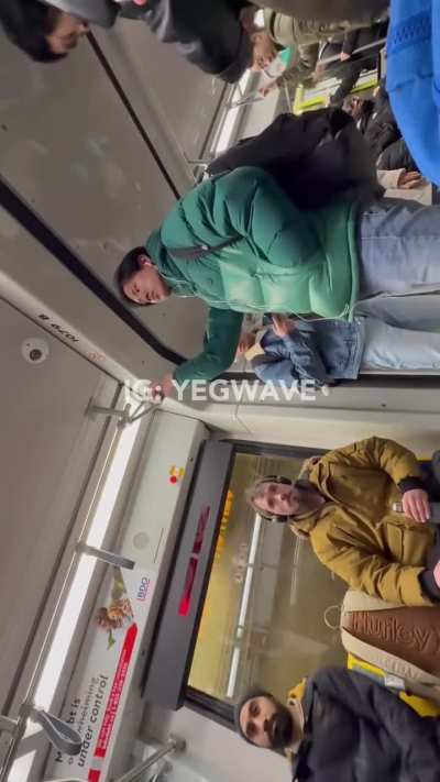 Man starring intensely at a muslim girl on a subway while another man intervenes.