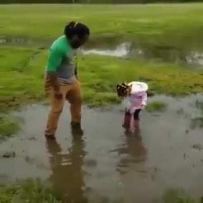 Teaching her dad how to properly use a puddle.