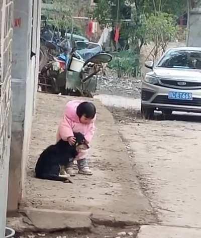 This little girl covers her dog's ears, so he won't be afraid of fireworks