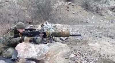UA POV A Maxim gun with a bipod, a scope and a suppressor is in use by a UAF soldier.